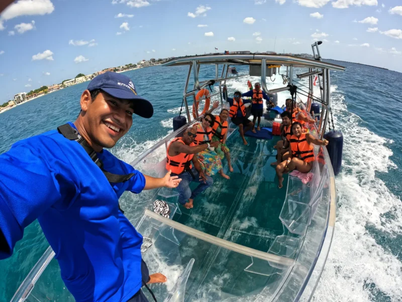 Tour guide Memo taking a selfie with happy passengers on the best glass bottom boat Cozumel alternative tour.