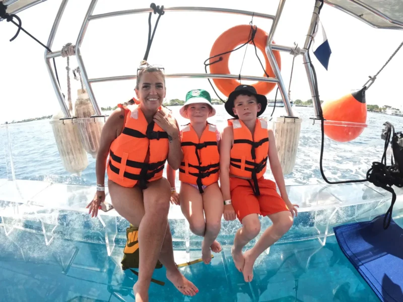 mama e hijos conociendo la naturaleza en un alancha de cristal en cozumel