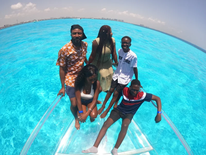 vista espectacular de una familia de norteamericana en las playas de cancun. todo esto sobrre un barco transparente cancún