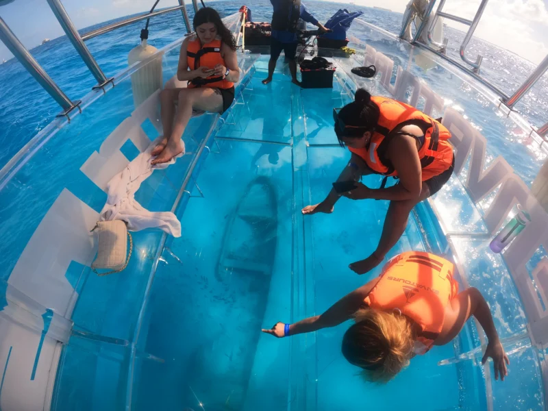 turistas disfrutando de una vista submarina en un clear boat isla mujeres