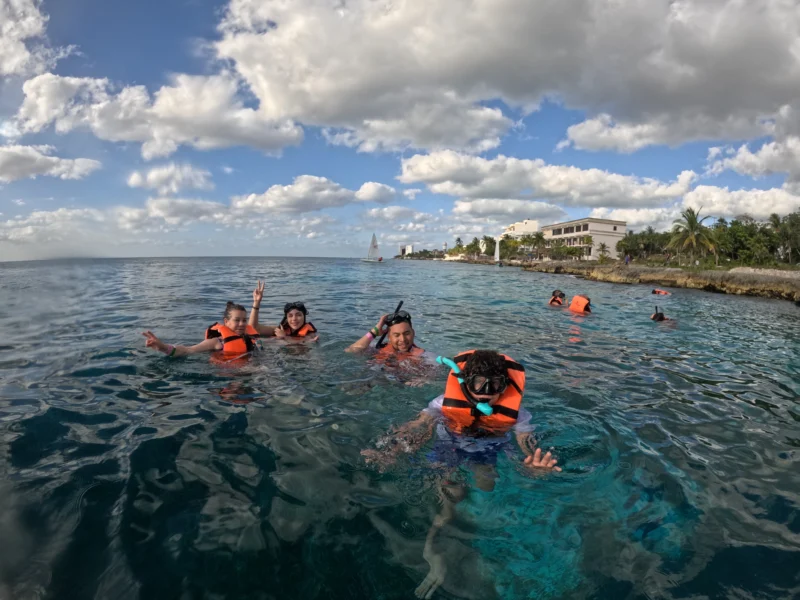 A group of friends enjoying a snorkeling tour in the beautiful clear waters of Cozumel with Transparent Boat Tours.