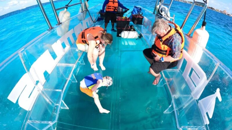 Family enjoying a transparent boat tour experience in Cozumel, Mexico, over the Mesoamerican Reef during the FIFA World Cup 2026.