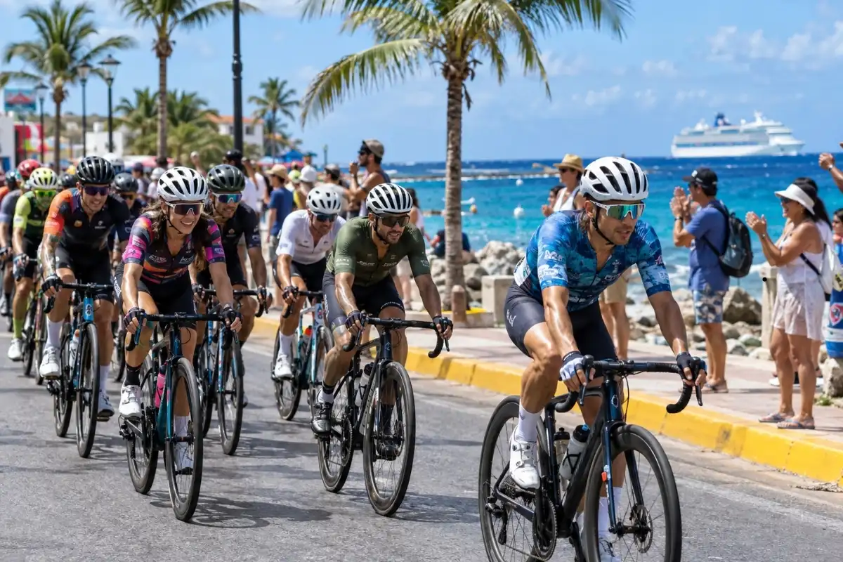Things to Do in Cozumel During GFNY: 2026 Race Week Guide 2 Road cyclists riding beside the waterfront in Cozumel during race week