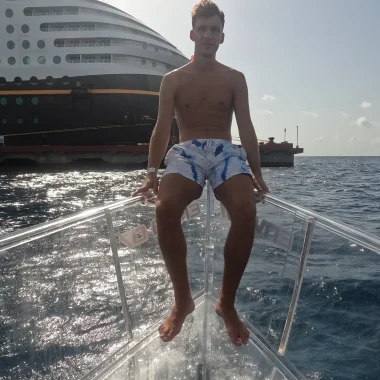 Bajo el Mar de Cozumel 25 muchacho tomando el sol en la lancha de cristal con el crucero de disney de fondo